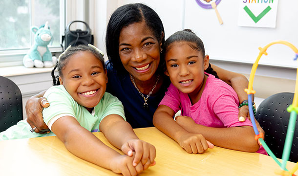 Three women at a Girl Scouts event wearing name tags
