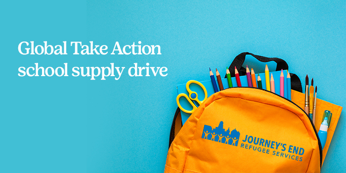 An orange backpack with the words "Journey's End Refugee Services" on it filled with school supplies